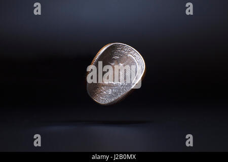 Close-up di danneggiato Washington quarto di dollaro la levitazione su sfondo nero Foto Stock