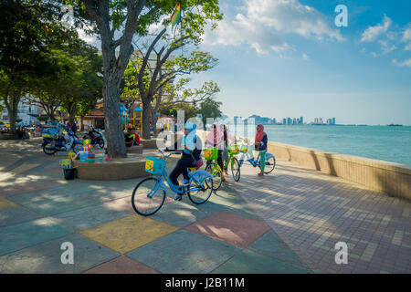 George Town, Malesia - 10 Marzo 2017: bella vista panoramica di unidentified donne musulmane in bicicletta lungo l'esplanade. Foto Stock