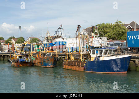 Fila di lavoro barche da pesca nel dock di campanatura in old Portsmouth. Un sacco di dettaglio che mostra la pesca trivelle e reti. Foto Stock