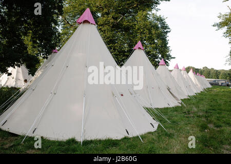 Riga di 'Glamping' tipis in festival campeggio campo. Foto Stock