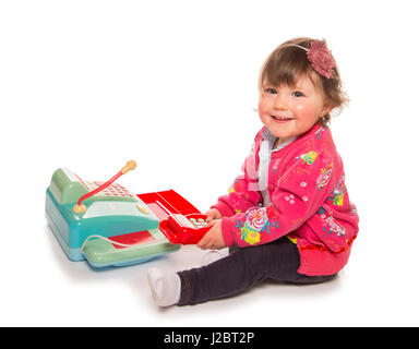 Bambino che gioca con un registratore di cassa in un studio Foto Stock