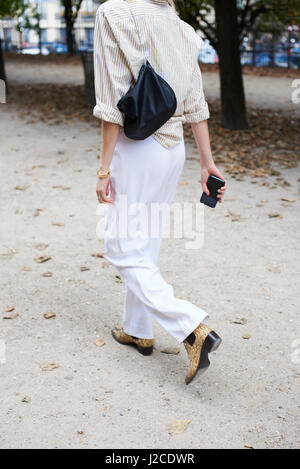 La donna in pantaloni bianchi e stivali snakeskin in street, il raccolto Foto Stock