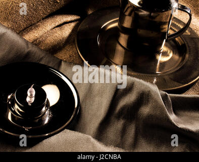 Un bronzo, oro e argento ancora vita impostare, contenente piastre di metallo, una teiera e una candela. Foto Stock