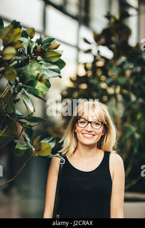 Giovane ragazza sorridente in posa all'aperto. Aggiunta foto filtro con grano. Foto Stock