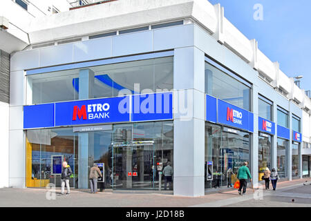 Metro filiale di banca segni e loghi su un sito d'angolo High Street Southend on Sea Essex England Regno Unito atm cash macchine punto situato nel negozio di vetro anteriore Foto Stock