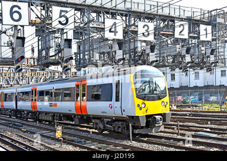 Heathrow Connect & treno di carrelli appena dopo la partenza Paddington per l'Aeroporto Heathrow di Londra REGNO UNITO al di sotto del gantry del segnale con grandi numeri la caratteristica di sicurezza Foto Stock