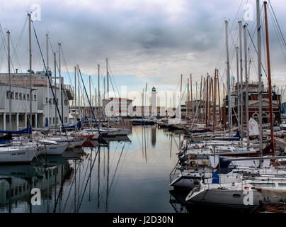 Navi ancorate nella città di Trieste canal sotto un cielo nuvoloso. Faro affacciato sulla città dalla distanza, ammirate una impostazione sun. Foto Stock