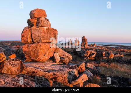 Canada, Nunavut, territorio, impostando il sole illumina il tumulo di pietra e croce di legno su Harbor Islands lungo la Baia di Hudson vicino al Circolo Polare Artico Foto Stock