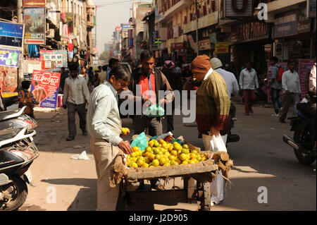 Gli uomini comprano frutta a una pressione di stallo stradale in paharganj a Delhi, India Foto Stock