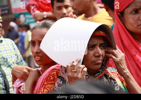 Dacca in Bangladesh. 27 apr, 2017. Un indumento femminile lavoratore si copre la testa con una carta durante le dimostrazioni di Dacca, capitale del Bangladesh, il 27 aprile 2017. Centinaia di lavoratori di indumento in Bangladesh capitale Dhaka giovedì in scena dimostrazioni arretrati esigente, bonus e fermare la delocalizzazione dei loro fabbrica dalla capitale. Credito: Salim Reza/Xinhua/Alamy Live News Foto Stock