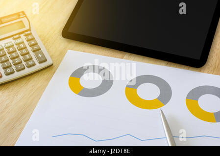 Finanziari grafico a torta con la calcolatrice e compressa, effetto luce soffusa Foto Stock