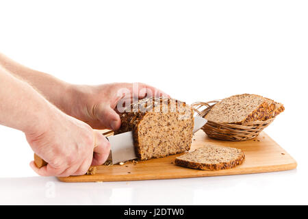 Pane fresco. La Crusca per affettare il pane su un tagliere. taglio mani il pane sulla tavola di legno Foto Stock