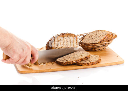 Pane fresco. La Crusca per affettare il pane su un tagliere. taglio mani il pane sulla tavola di legno Foto Stock