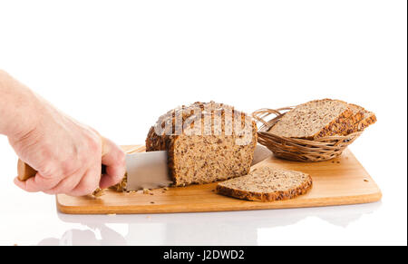 Pane fresco. La Crusca per affettare il pane su un tagliere. taglio mani il pane sulla tavola di legno Foto Stock