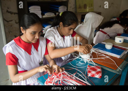 Ipovedenti ragazza gli studenti fanno sacchetti in aula a Battista missione scuola integrata in Mirpur. Dacca in Bangladesh. Foto Stock