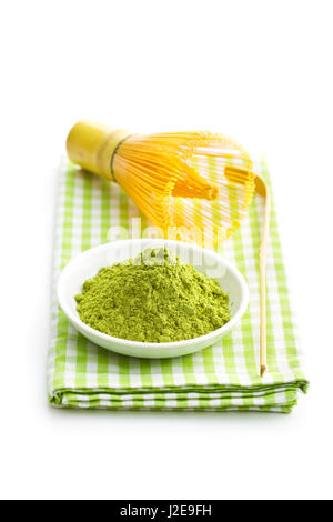 Verde matcha tè in polvere e mescolare con una frusta di bambù isolati su sfondo bianco. Foto Stock