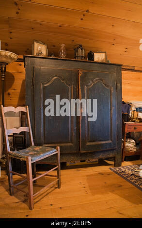 Sedia antica, blu comò in legno decorato con cornici, lampade a olio nella camera da letto principale sul pavimento del piano superiore all'interno di un vecchio 1840s Canadiana house Foto Stock