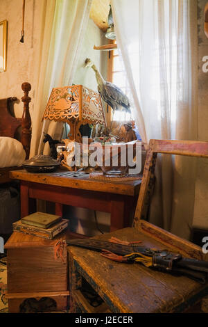 Collectibles visualizzato sul comodino e sedia in una camera da letto sul pavimento del piano superiore all'interno di un vecchio Canadiana 1840s fieldstone cottage in stile casa Foto Stock