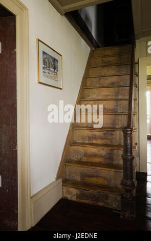 In legno antico ripida scala in originale cucina e sala da pranzo che conduce al piano superiore piano all'interno di un vecchio 1785 fieldstone cottage in stile casa residenziale Foto Stock