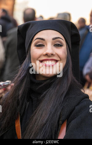 L'Italia, Sardegna, Gavoi. Donna sorridente vestita di nero, prendendo parte a una tradizionale festa pagana. Foto Stock