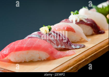 Sushi fresco con Salmone, riso, calamari, wasabi sul vassoio in legno Foto Stock