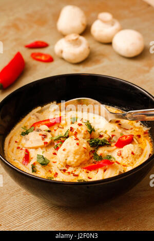 Pesce speziato a sfera con zuppa di latte di cocco e funghi Foto Stock