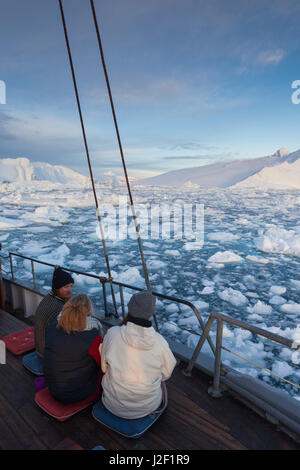 La Groenlandia, Disko Bay, Ilulissat, a bordo di barche da pesca nel ghiaccio galleggiante, tramonto Foto Stock