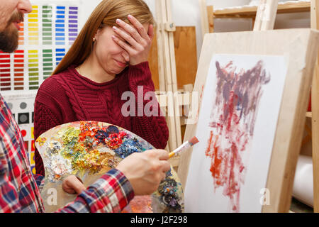 Insegnante è molto arrabbiato con il lavoro dello studente. Una lezione alla scuola d'arte. Corsi di disegno per adulti. Foto Stock