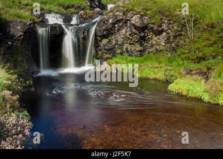 Uno dei fiumi che dalla Black Cuillins montagne scorre verso il basso è caratterizzata da molte cascate e deep blue piscine, la fata piscine. Isola di Skye in Scozia Foto Stock