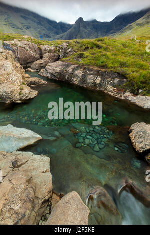 Uno dei fiumi che dalla Black Cuillins montagne scorre verso il basso è caratterizzata da molte cascate e deep blue piscine, la fata piscine. Isola di Skye in Scozia Foto Stock