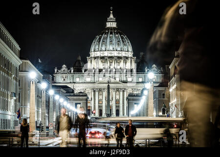 Vista illuminata Basilica di San Pietro, Via della Conciliazione e sentieri di luce delle vetture in Roma, Italia Foto Stock