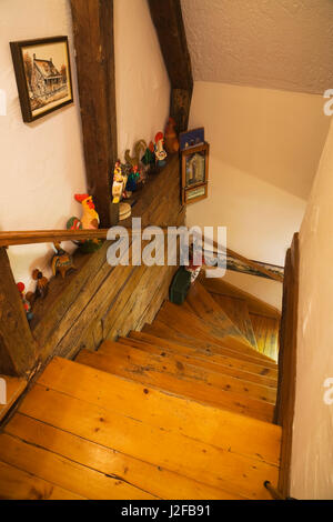 Scala in legno che conduce al piano terra all'interno di un ricostruito (1976) in stile cottage home log. Foto Stock