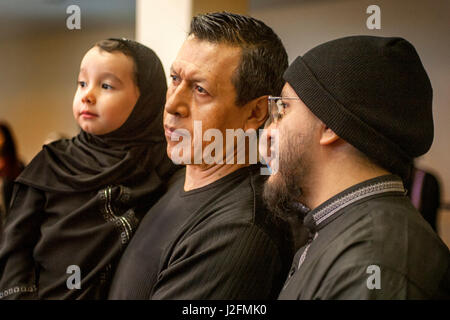 Un musulmano Padre tiene il suo bimbo figlio nei tradizionali del Medio Oriente durante l abbigliamento religiosi islamici servizi a un Anaheim, CA, la moschea. Foto Stock