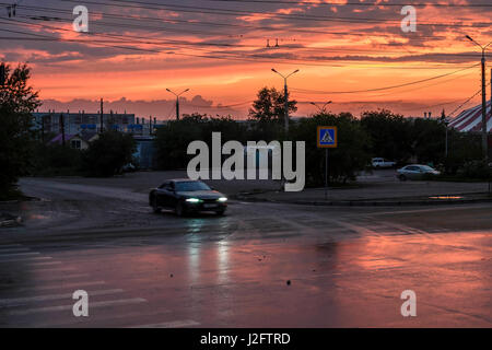 Colorati e tramonto rosso si illumina la strada in città. bellissimo cielo al tramonto. Foto Stock
