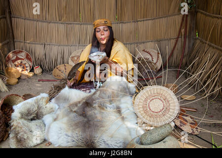 California donna indigena della nazione Acjachemen (San Juan Capistrano missione indiani) burns salvia essiccata in un guscio di abalone come medicina all'interno di un tradizionale Tule reed shelter. (MR) Foto Stock