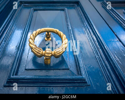 Oro antico o porta di ottone respingente su un dipinto di blu porta. Vecchia casa cittadina in Sliema Malta. Foto Stock