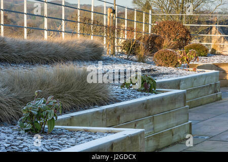 Inverno gelido, bellissimo giardino privato, con design elegante e contemporaneo, hard landscaping & nuova semina su letti sollevata - Yorkshire, Inghilterra, Regno Unito. Foto Stock