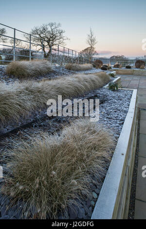 Inverno gelido, bellissimo giardino privato, con design elegante e contemporaneo, hard landscaping & nuova semina su letti sollevata - Yorkshire, Inghilterra, Regno Unito. Foto Stock