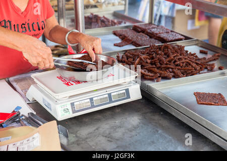 GEORGE TOWN, Malesia - 23 Marzo: Donna pesare cinese di maiale essiccate presso la strada del mercato il 23 marzo 2016 su George Town, Malaysia. Foto Stock