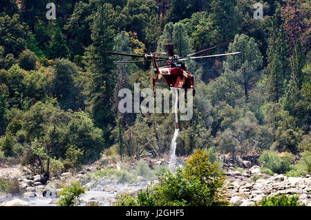 Stati Uniti, California, El Portal, S-64 Skycrane elicottero prendendo acqua dal fiume Merced alla lotta contro gli incendi forestali Foto Stock