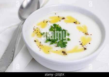 Una scodella di fagioli bianchi purè zuppa con burro piccante e spezie, erbe Foto Stock