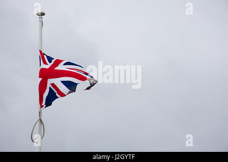 Bandiera britannica , Unione Jack sventolano al vento contro il grigio ,cielo nuvoloso. Foto Stock