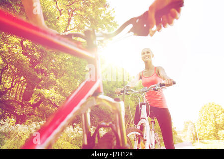 Close up di coppia felice bicicletta equitazione all'aperto Foto Stock