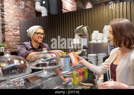 Donna felice acquisto chai latte drink presso vegan cafe Foto Stock