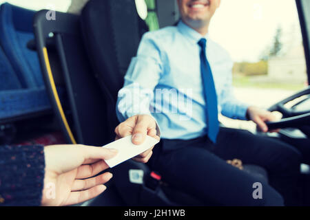 Chiusura del conducente di bus la vendita di biglietto per passeggero Foto Stock