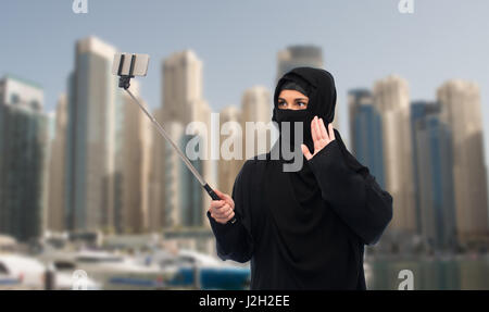 Donna musulmana in hijab tenendo selfie tramite smartphone Foto Stock