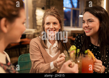 Happy amici tintinnio bevande al ristorante Foto Stock