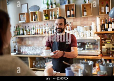 Uomo o cameriere che serve il cliente presso la caffetteria Foto Stock