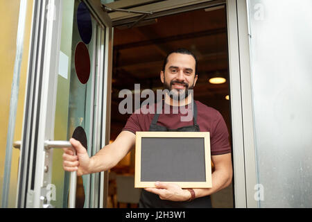 Uomo o cameriere con blackboard presso il bar porta di ingresso Foto Stock