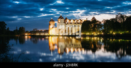 Mir, Bielorussia. Panorama del complesso del Castello di Mir In brillante illuminazione serale con candelette di riflessioni sul lago di acqua. Famoso punto di riferimento, antichi Monum gotica Foto Stock